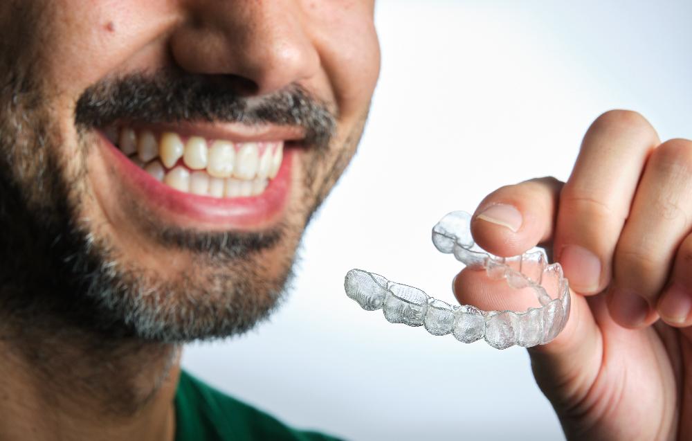 A man holding an Invisalign tray