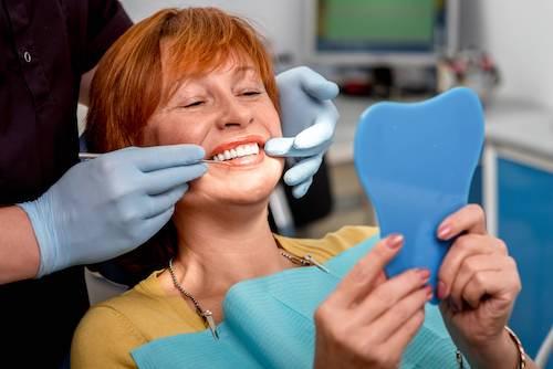 A woman looking at her new dental implants