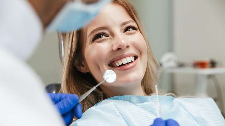 A smiling woman receiving a dental exam