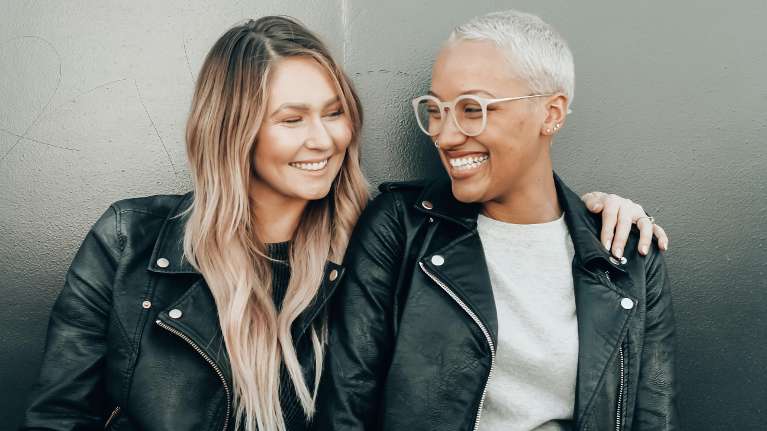 Two friends with dental implants smiling