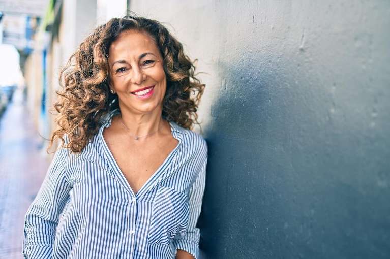 A smiling woman wearing a striped blue shirt