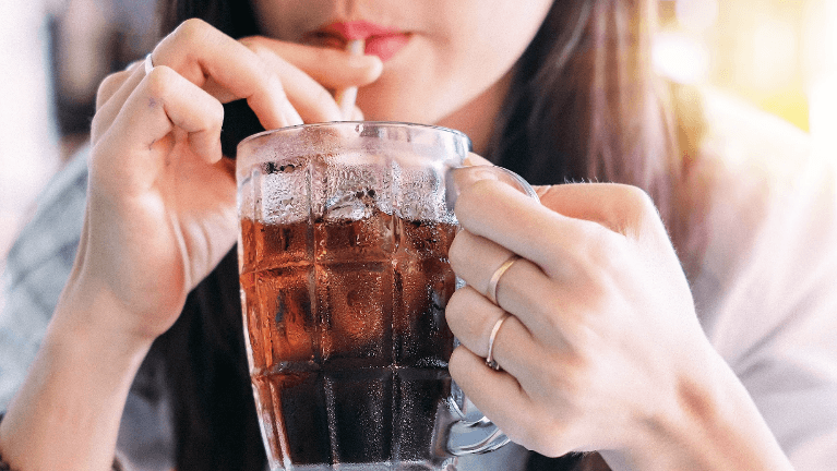 A woman drinking soda with a straw