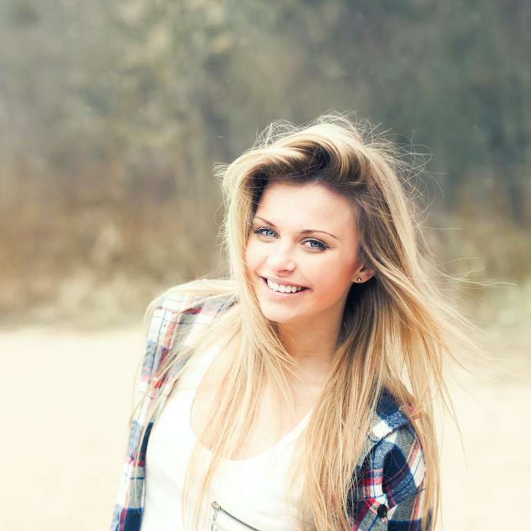 A smiling woman standing in a field