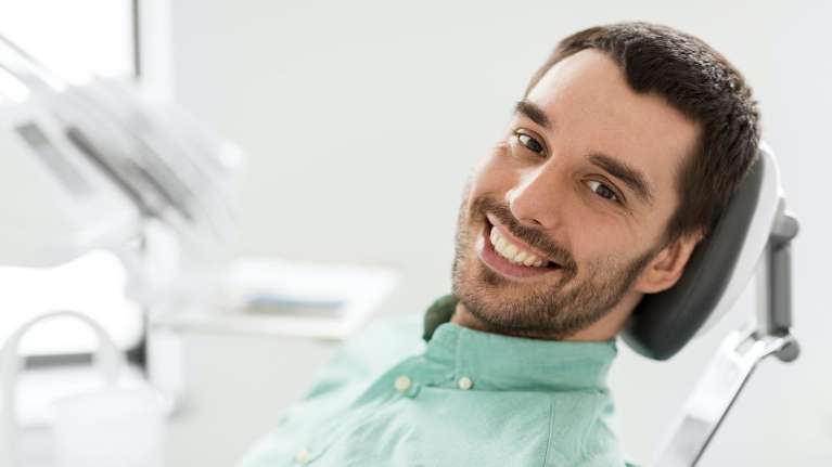 A smiling man in the dentist's chair