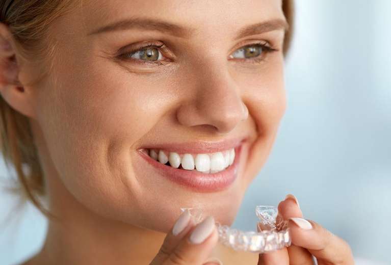 A woman holding her Invisalign tray